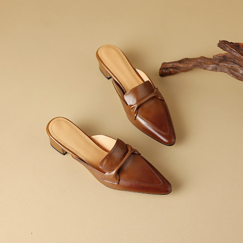 Close-up of a stylish white leather mule, featuring a delicate bow and comfortable design