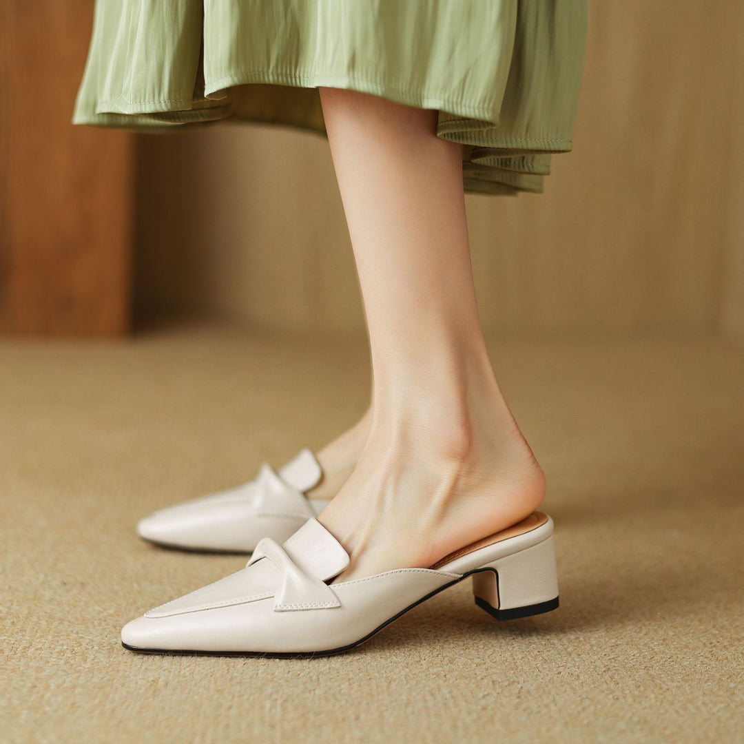 Stylish black women's mules made of leather, featuring a prominent bow, chic and comfy