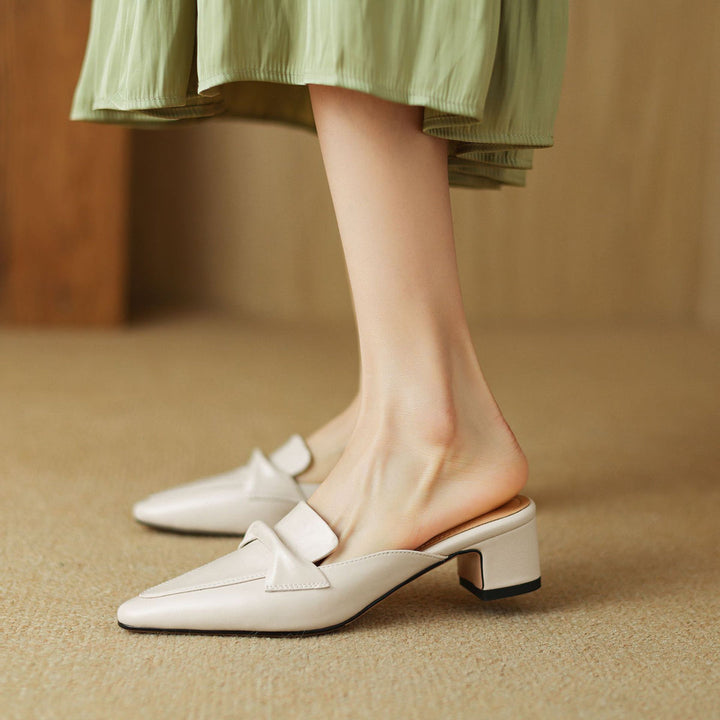 Stylish black women's mules made of leather, featuring a prominent bow, chic and comfy