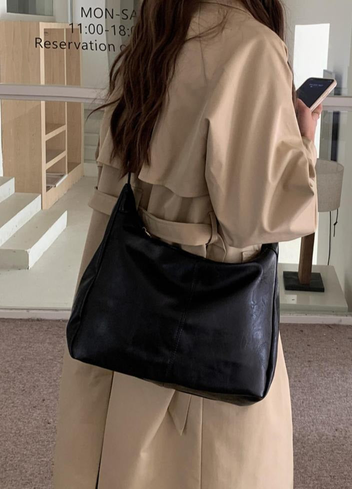 Stylish women's crossbody bag in black faux leather, versatile and chic for daily use
