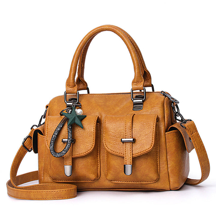 Close-up of the hardware and stitching detail on a women's elegant faux leather handbag.