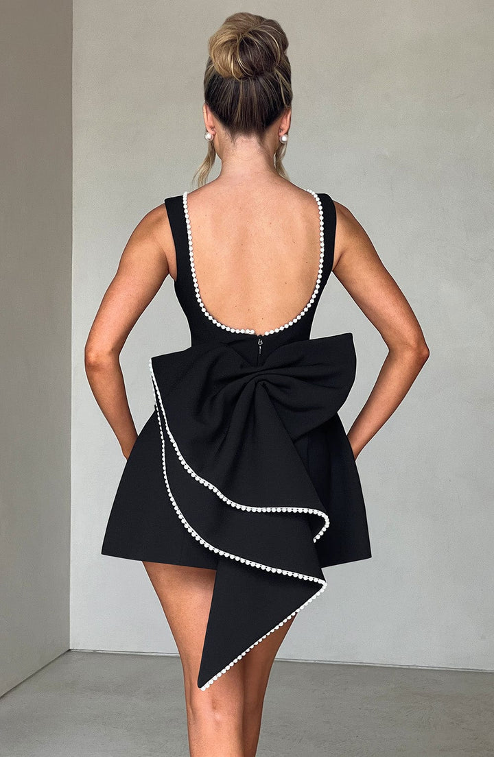 Back view of a white structured mini dress, emphasizing its formal and elegant appeal.