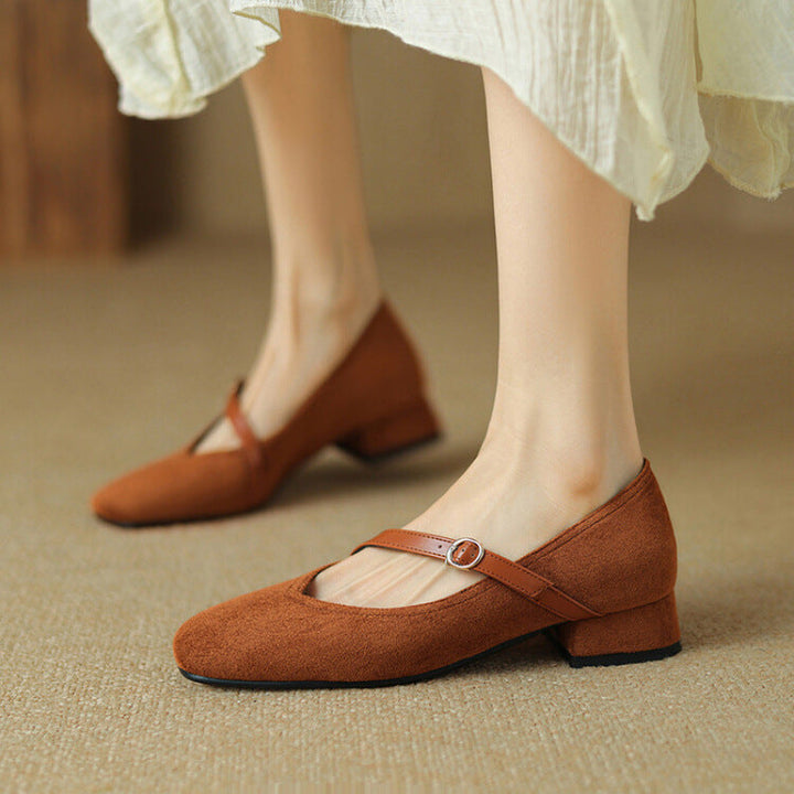 Tan suede block heel pumps with a stylish buckle strap, comfortable for all-day wear.