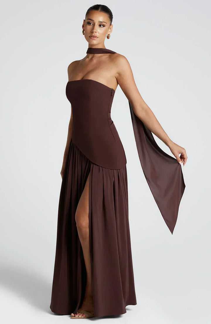 Side view of a women's burgundy asymmetric maxi dress, long, elegant, and ideal for wedding guests.