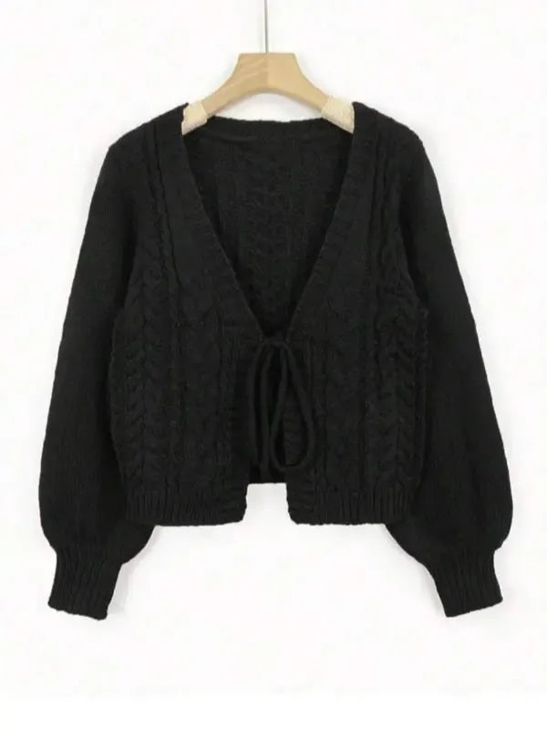 Close-up of the intricate cable knit pattern on an elegant tie-front cardigan for women.