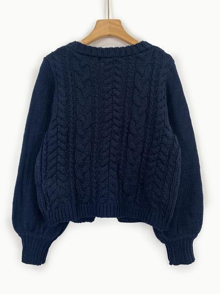 Soft texture, elegant women's cable knit cardigan with a tie-front design, cozy knitwear fashion.