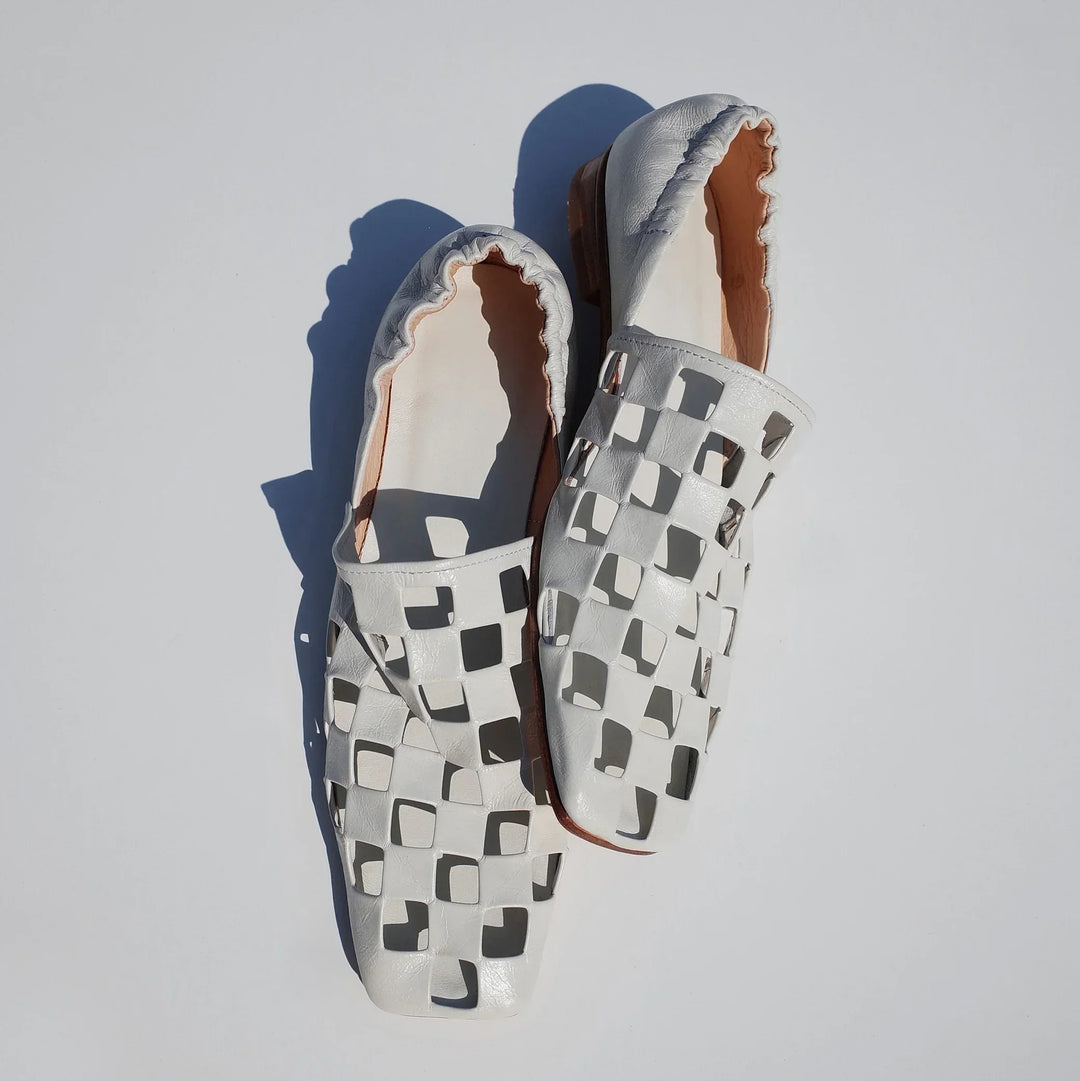 Women's checkered leather mules, a versatile footwear choice for adding a touch of elegance to any look.