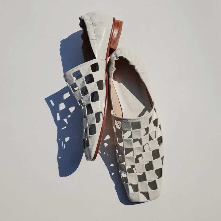 Women's checkered leather mules on a model, demonstrating their chic and versatile footwear appeal.