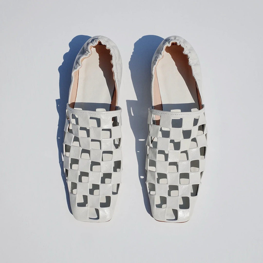 A single women's modern checkered leather mule, emphasizing its unique pattern and comfortable fit.