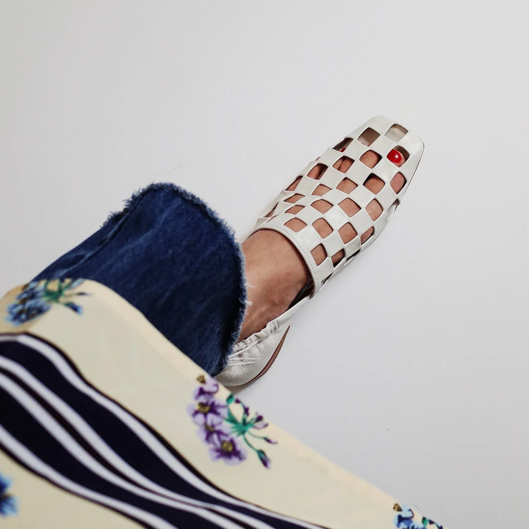 Stylish women's checkered leather slip-on mules, a blend of casual comfort and modern elegance.