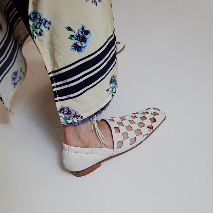 Detail of the checkered pattern on women's leather mules, showing the texture and design up close.