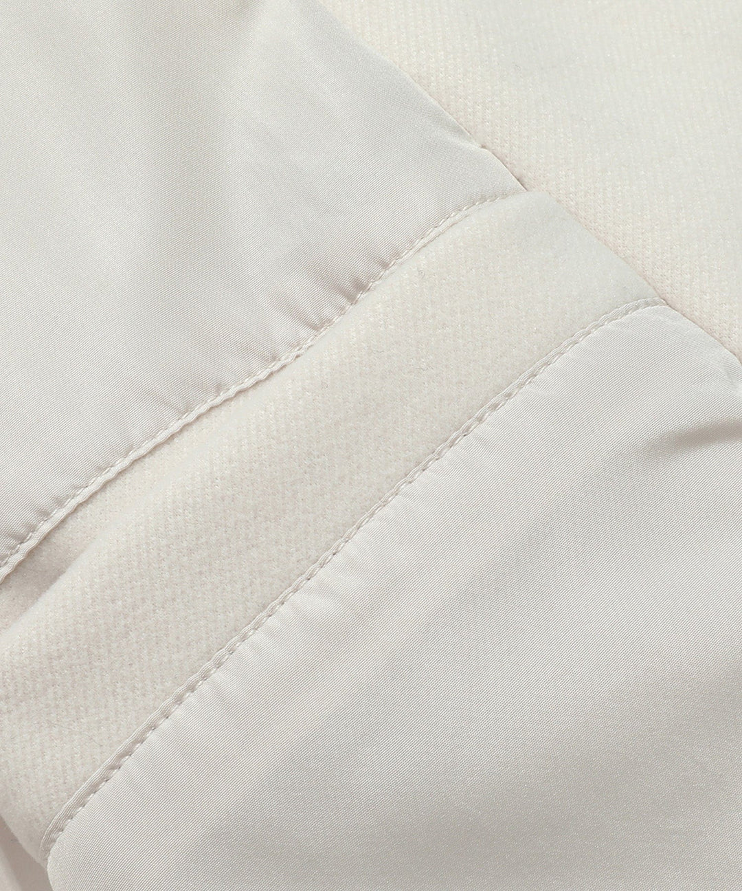 Detailed shot of the collar and lapels of a women's classic white double-breasted trench coat.