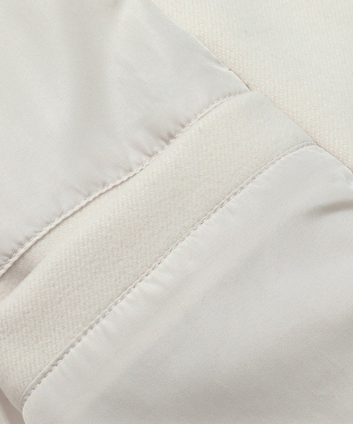Detailed shot of the collar and lapels of a women's classic white double-breasted trench coat.