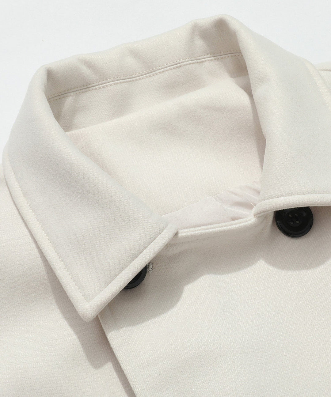 Women's white trench coat, an essential double-breasted outerwear piece for elegant spring and fall fashion.