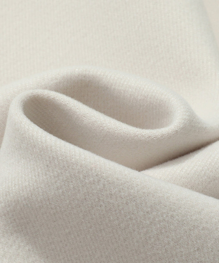 Close-up of the double-breasted detail on a white women's trench coat, highlighting the style.
