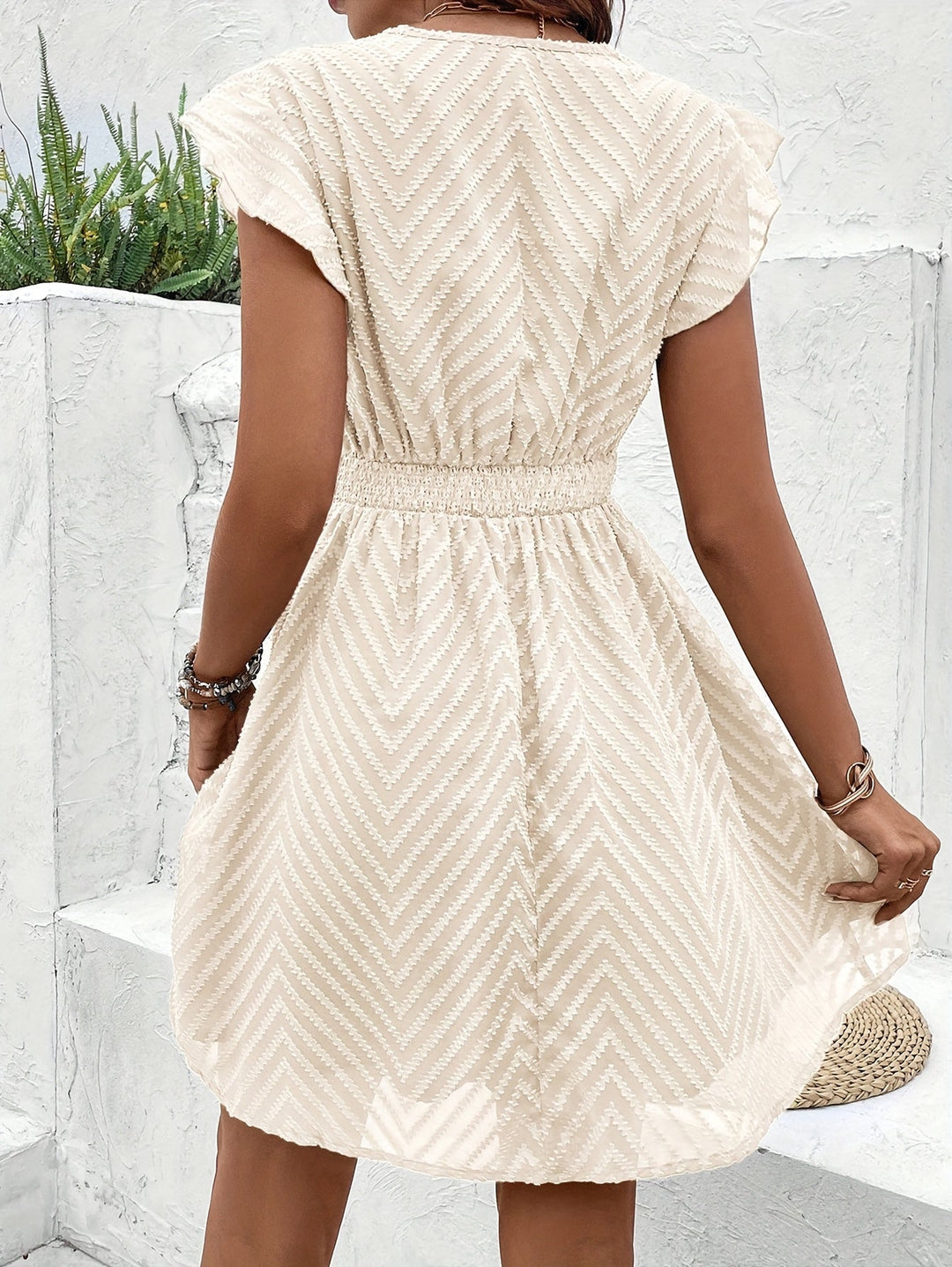Women's elegant mini dress with V-neckline & flutter sleeves, ideal for a casual or party look.