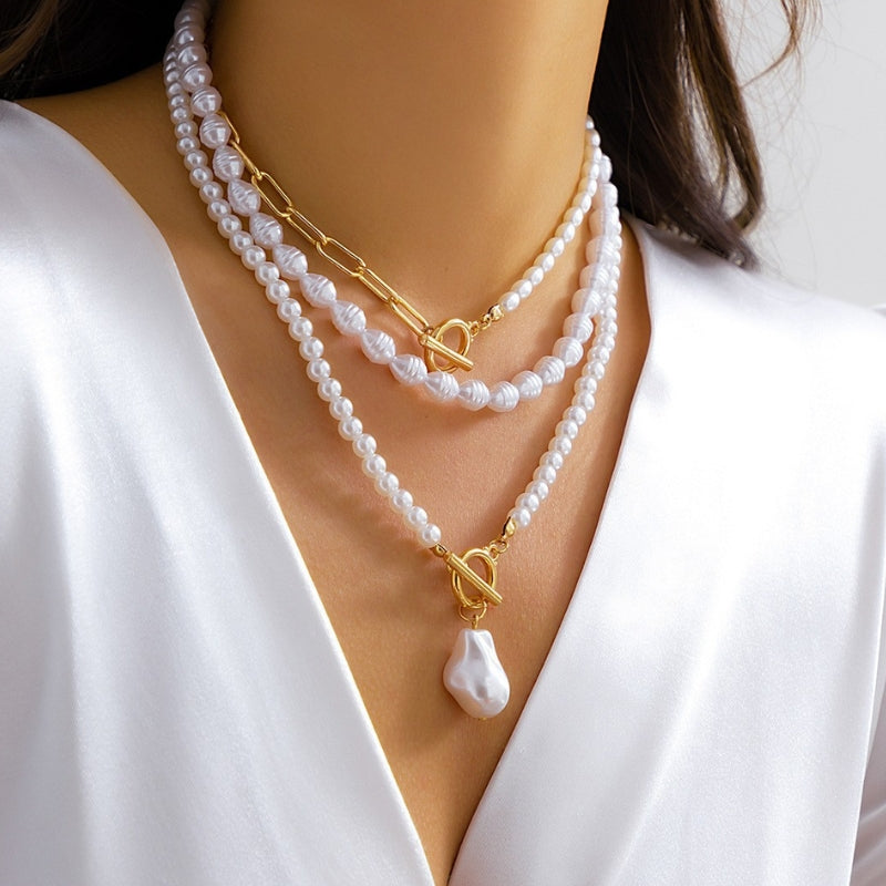 Fashionable layered pearl and gold-tone necklace for women, showcasing a mix of delicate chains and lustrous pearls.