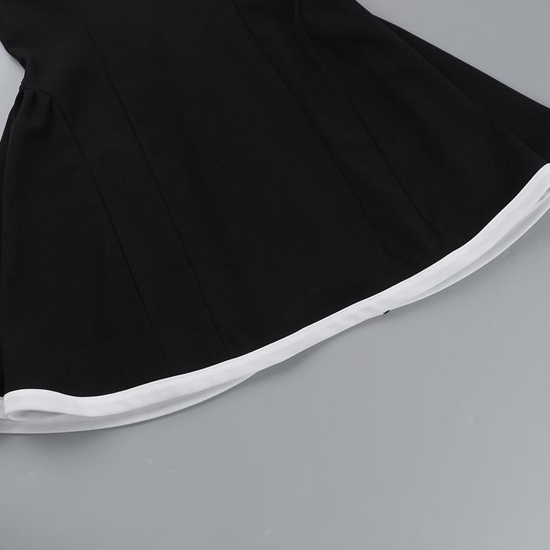 Full-length view of a women's elegant black mini dress with a distinctive contrast neckline