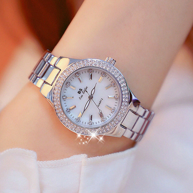 Glossy stainless steel women's analog quartz watch. Silver, gold, or two-tone water-resistant fashion timepiece.