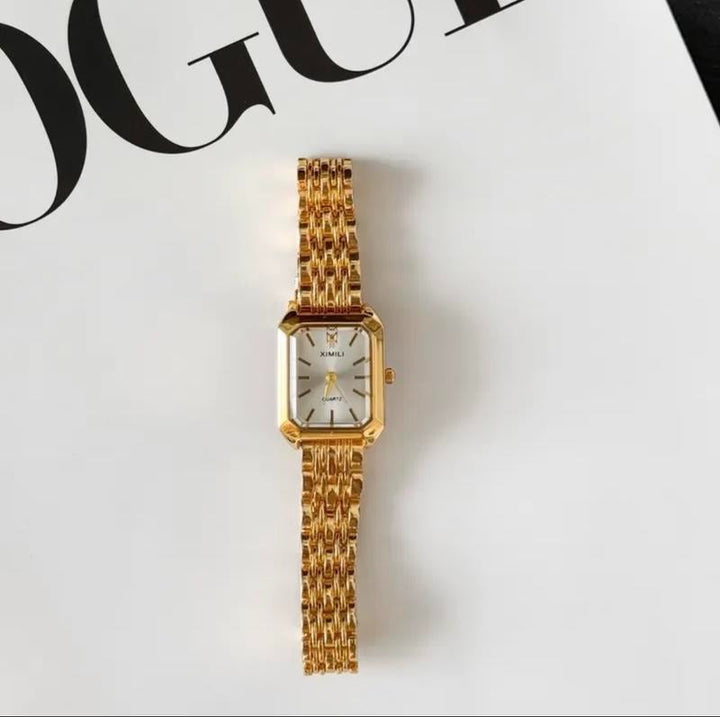 Fashionable women's gold-tone rectangular watch, perfect for an elegant look, shown on a wrist.