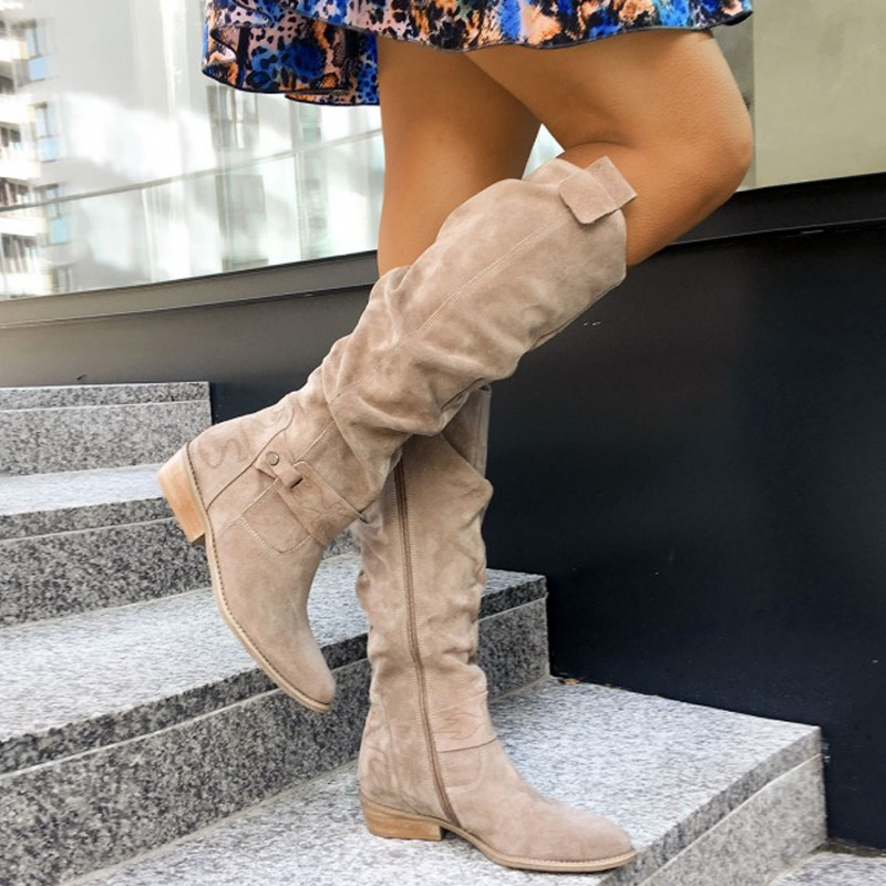 Close-up of the soft suede texture on elegant women's knee-high boots, highlighting quality craftsmanship.