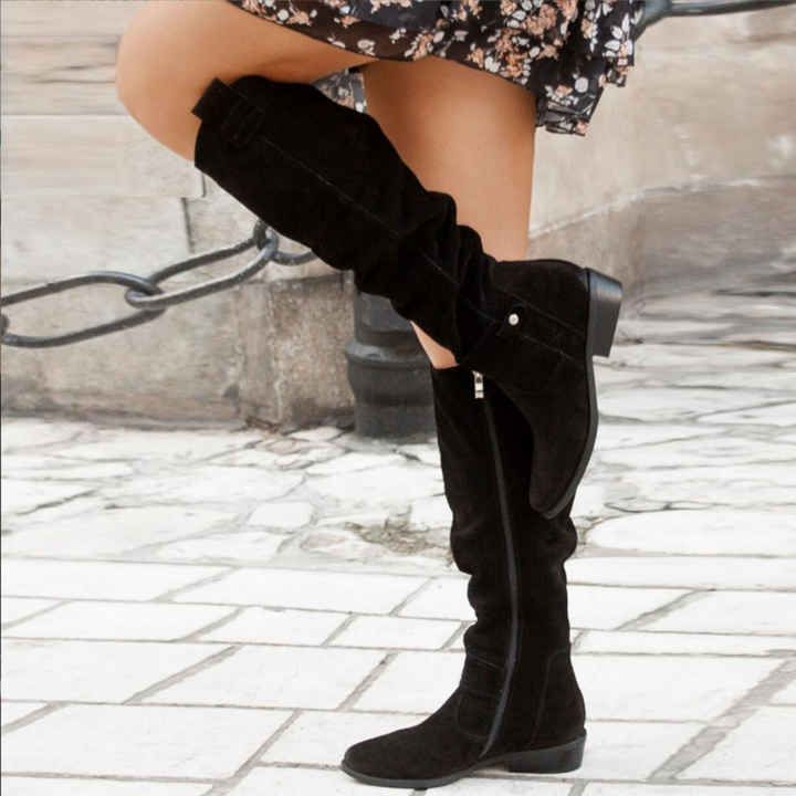 Detailed shot of the shaft and heel of women's suede knee-high boots, showcasing elegant footwear.