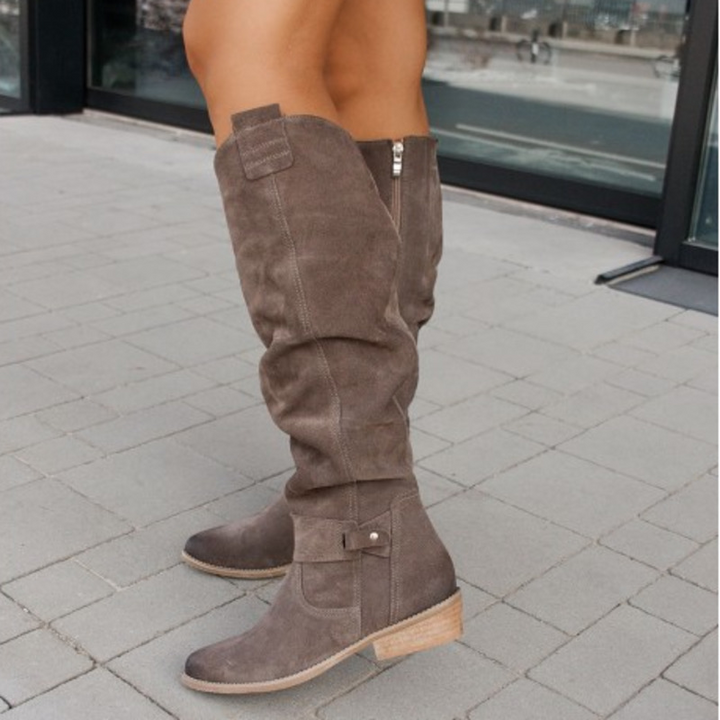 Women's soft suede knee-high boots in a deep forest green, adding a pop of color to fall fashion.