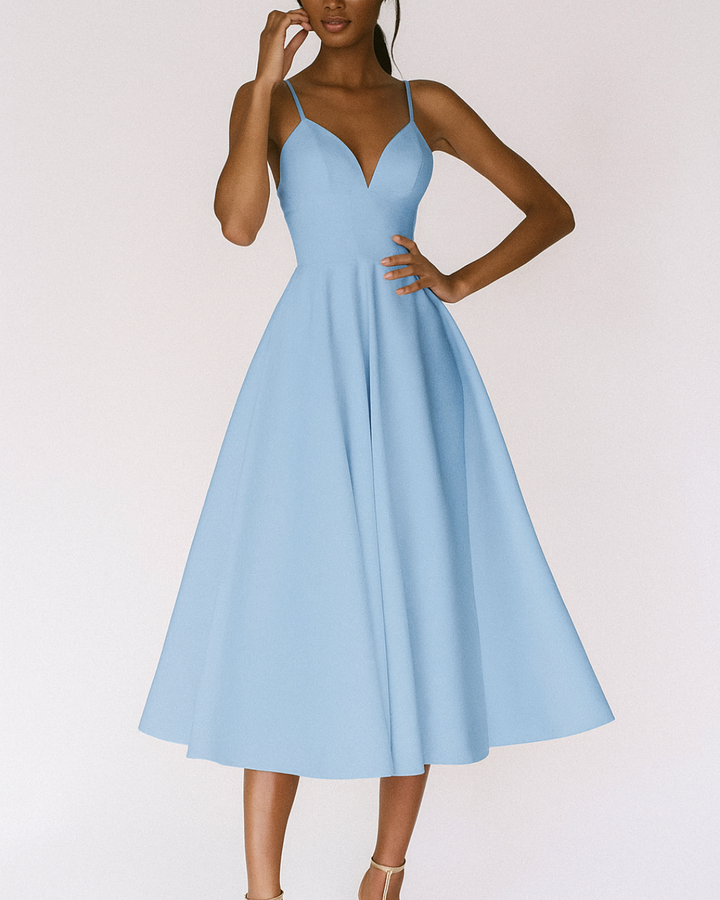 Close-up of the delicate straps and neckline of a women's elegant midi dress, perfect for wedding guests