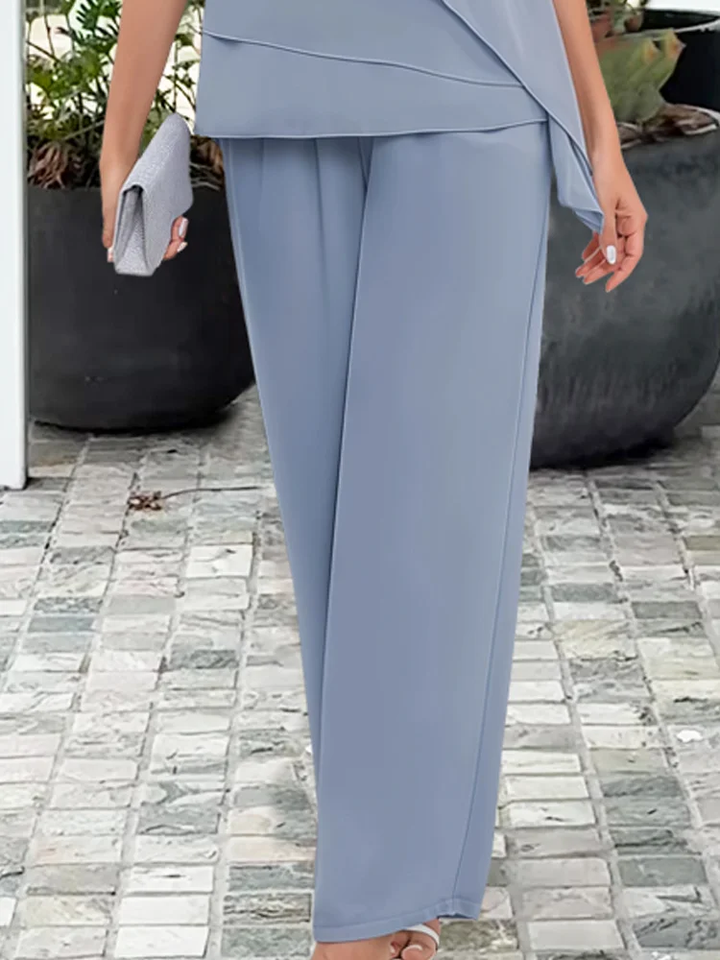 Stylish women's two-piece outfit featuring a sophisticated tiered cape top and elegant wide-leg trousers.