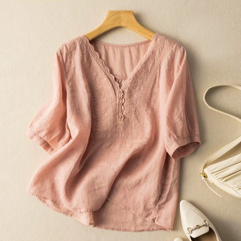 Elegant women's white blouse with colorful floral embroidery, V-neck, and relaxed fit. Perfect for spring/summer chic.