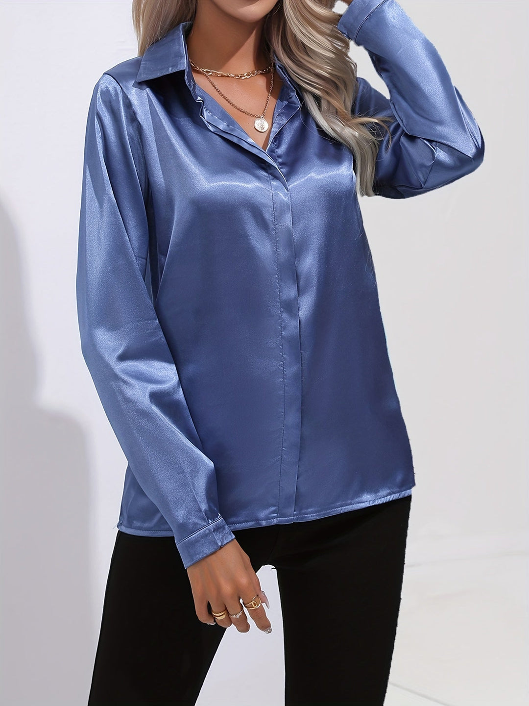 Close-up of a women's satin button down blouse, highlighting the fabric's smooth texture and buttons.