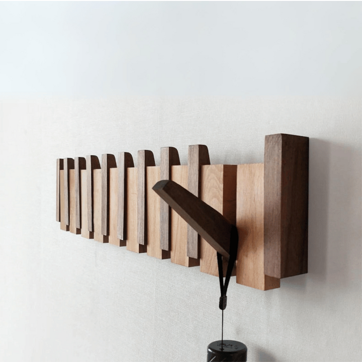 "Elegant wooden coat rack with magnetic hooks, crafted from walnut and beech, offering a sleek, natural aesthetic."