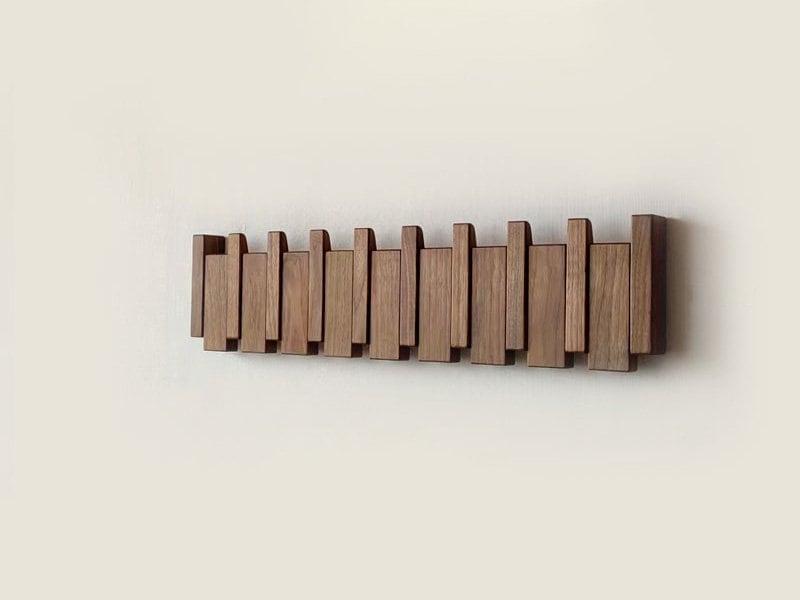 "Elegant wooden coat rack with magnetic hooks, crafted from walnut and beech, offering a sleek, natural aesthetic."