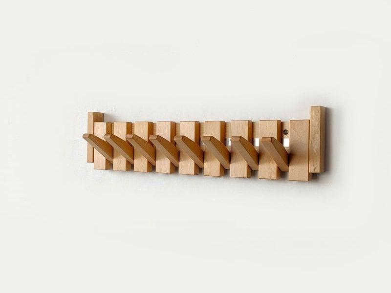"Elegant wooden coat rack with magnetic hooks, crafted from walnut and beech, offering a sleek, natural aesthetic."
