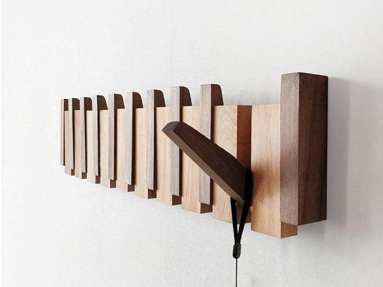 "Elegant wooden coat rack with magnetic hooks, crafted from walnut and beech, offering a sleek, natural aesthetic."