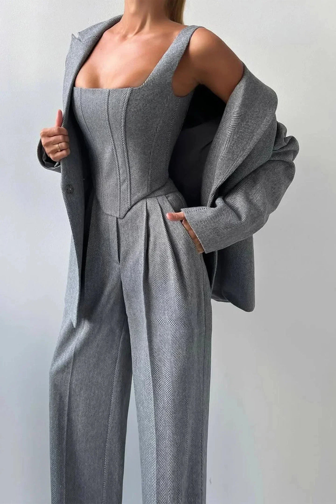 Modern women's fashion set: a fitted corset, high-waisted wide leg pants & relaxed oversized blazer for chic style.