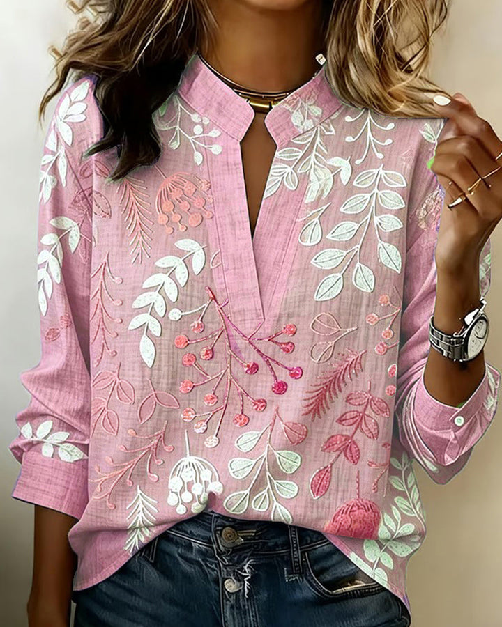 Detail shot of the fabric and pastel floral design on a women's V-neck blouse.