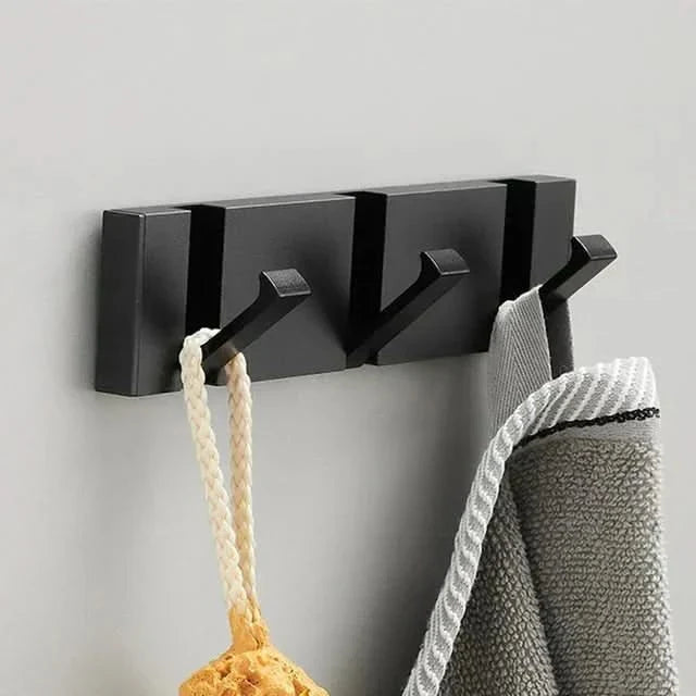 Multiple folding wall hooks organized on a wall, showcasing space-saving design.