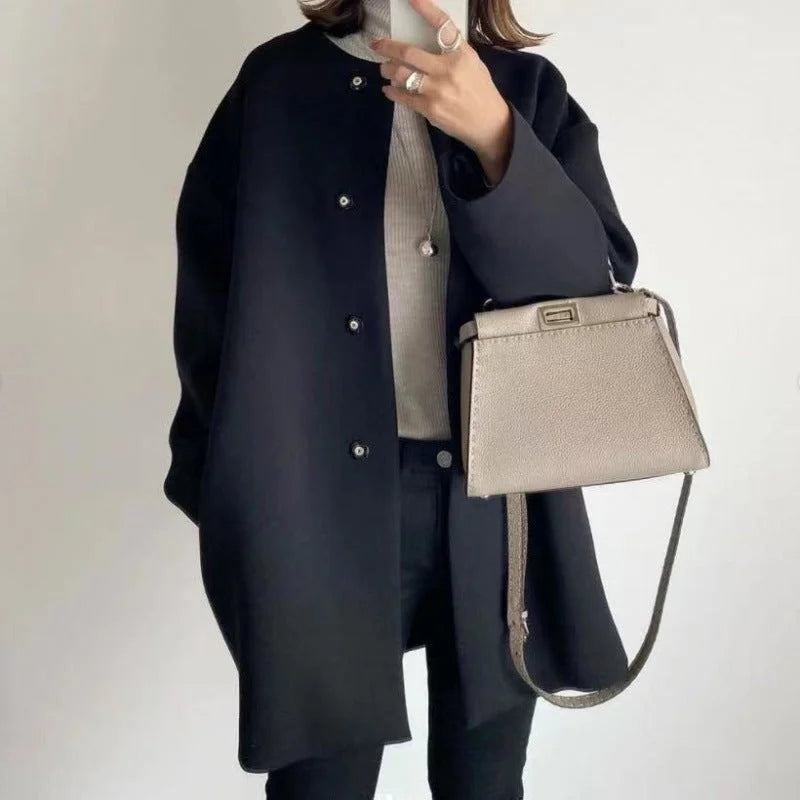 Elegant oversized button-front long coat for women. Minimalist design, ideal for chic office or casual winter fashion.