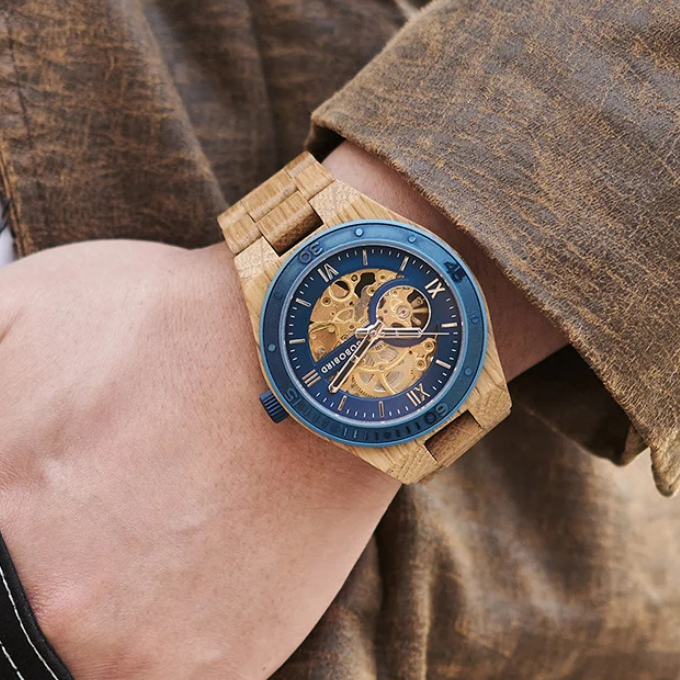 Top-down view of men's automatic wood watch, skeleton dial revealing complex internal workings.