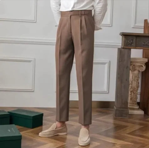Fashion shot of men's navy blue cropped suit trousers, styled with loafers, highlighting contemporary formalwear.