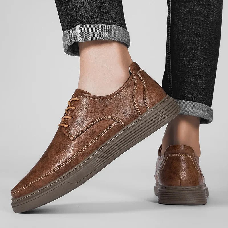 Men's grey leather dress sneaker on a white background, highlighting its sleek design and comfort.