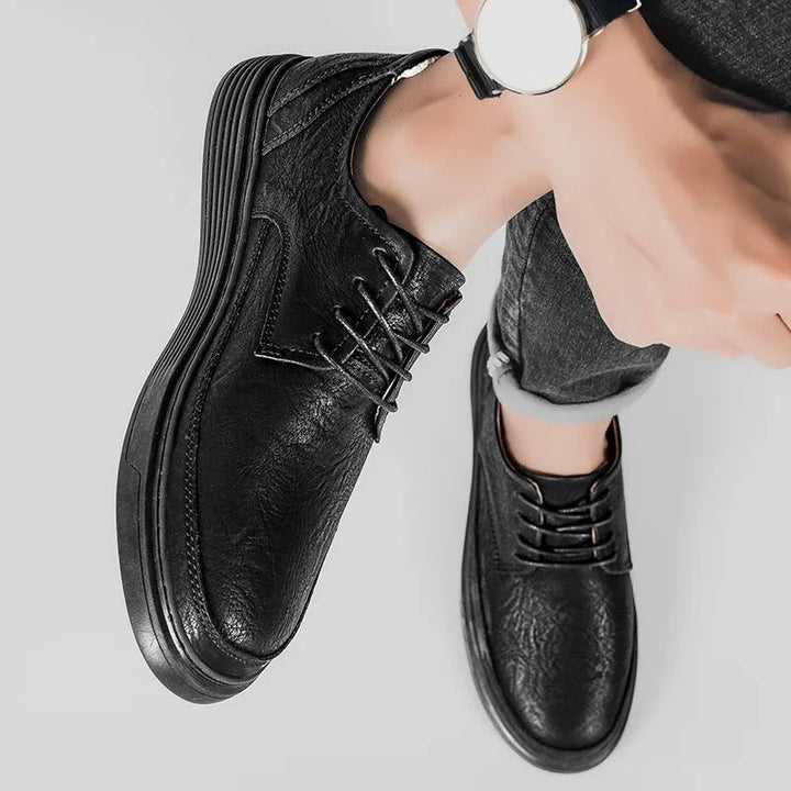 Pair of men's leather dress sneakers in a neutral color, a versatile choice for any wardrobe.