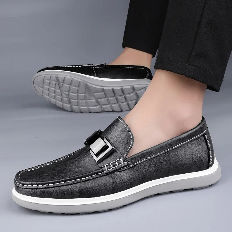 Men's gray leather loafers worn casually with jeans, showcasing comfort and style.