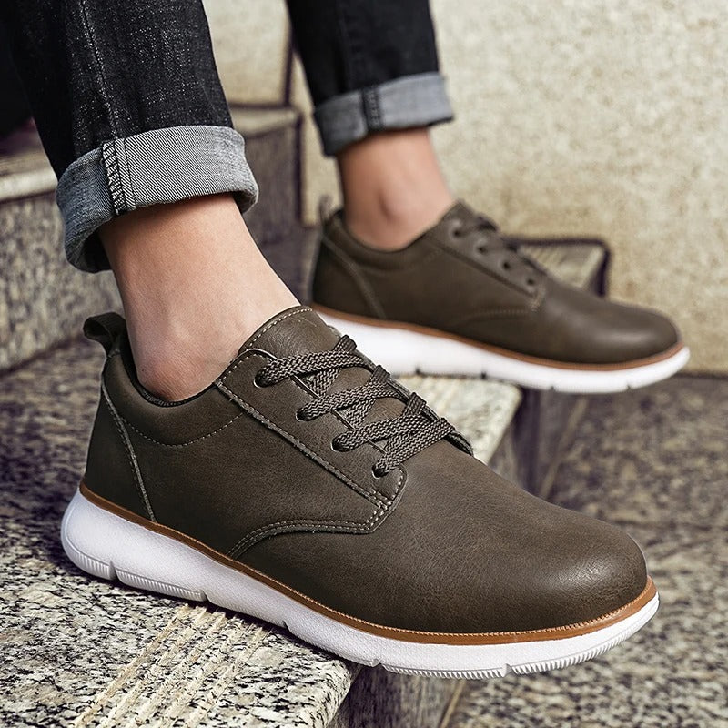 Side view of a men's black leather sneaker, showcasing its streamlined profile and secure lace-up closure.