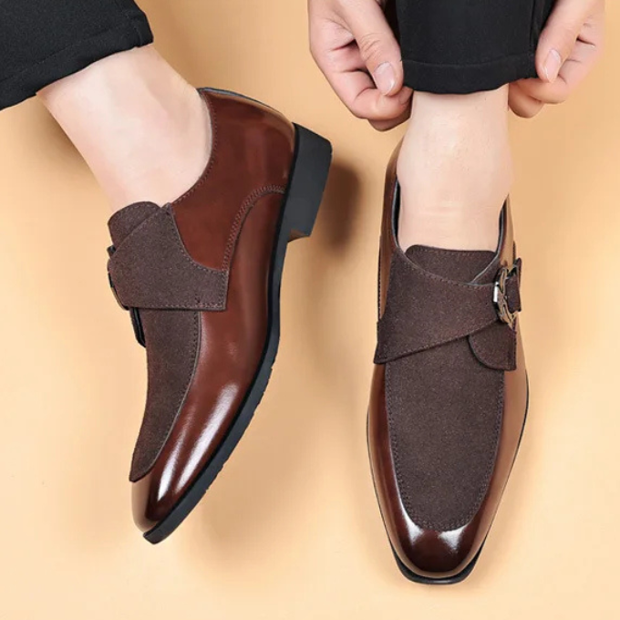 Detailed shot of the buckle on men's black luxury leather & suede loafers, a key aesthetic feature.