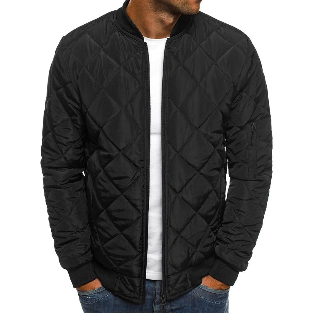 Man wearing a stylish quilted streetwear jacket in a city setting, showcasing modern men's apparel
