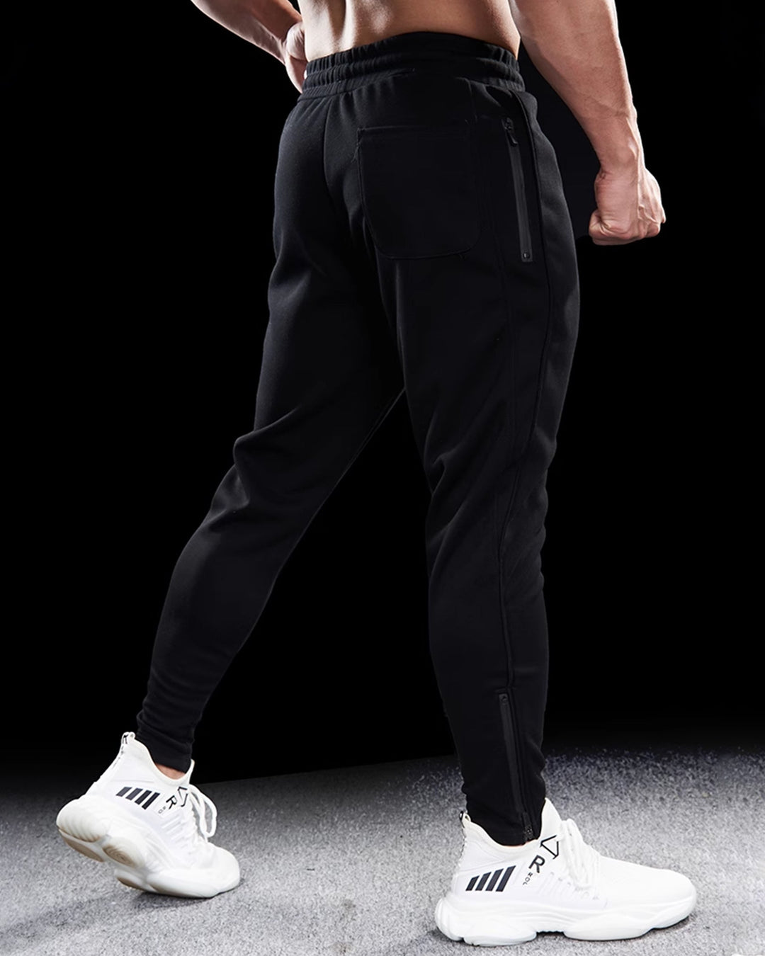 Collection of men's tapered track joggers in various colors, all featuring zippered hems and a casual fit.