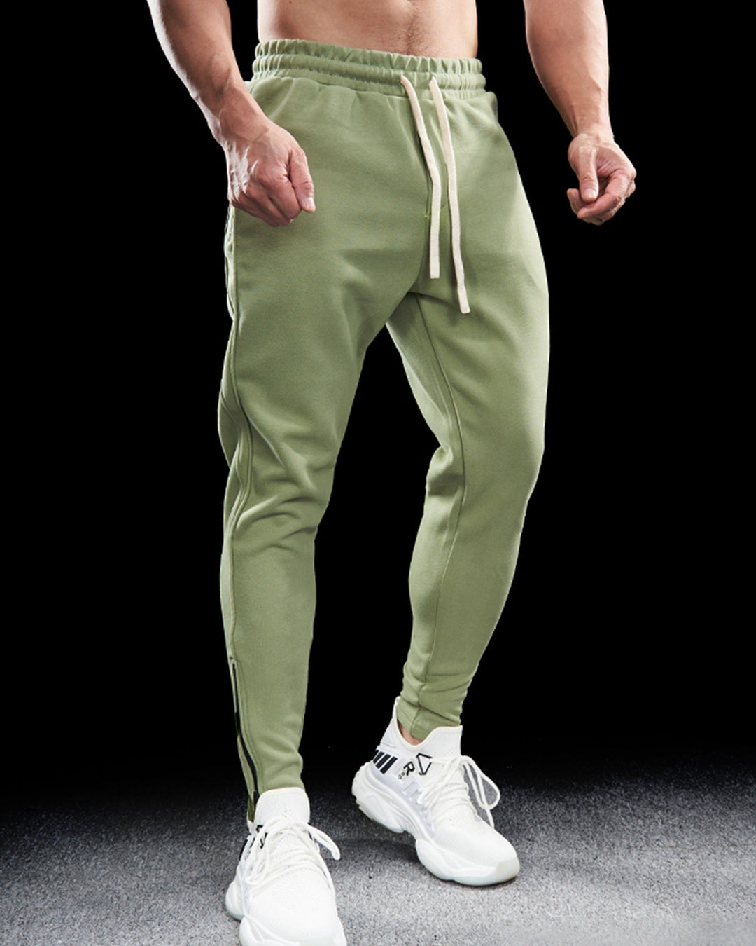 Men's casual wear joggers in a dark color, cotton blend, tapered leg, and practical zippered hems.