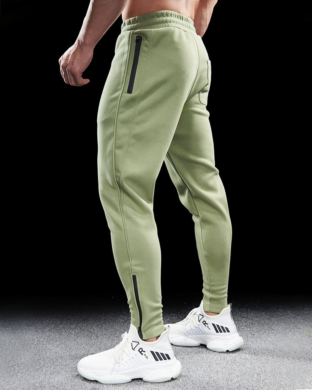 Folded men's track pants showing tapered fit and zippered ankle detail. Essential activewear apparel.